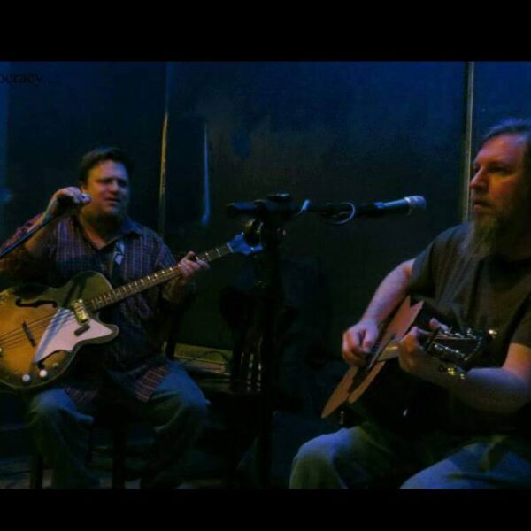 The Harris Brothers at a previous show playing guitar and singing besides each other