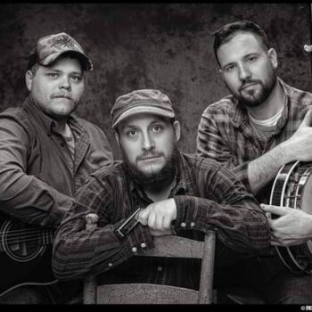 Black and white photo of Craig Street band members together with one in the middle front of the other two on each side